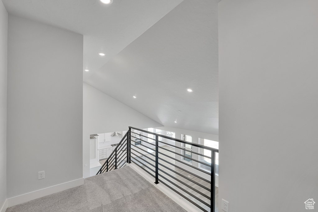 Corridor with an upstairs landing, recessed lighting, baseboards, vaulted ceiling, and carpet
