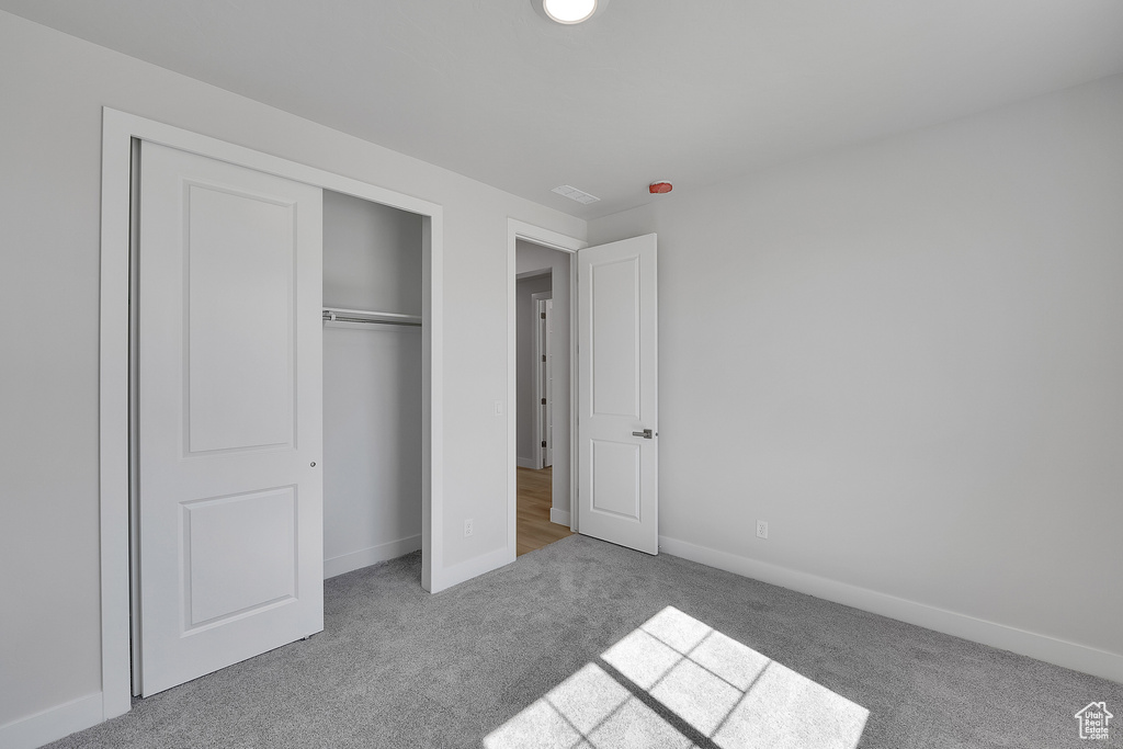 Unfurnished bedroom featuring carpet, baseboards, and a closet