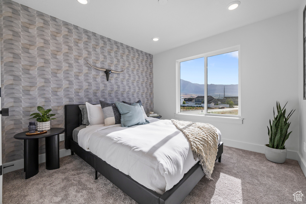 Carpeted bedroom with recessed lighting, an accent wall, baseboards, and a mountain view