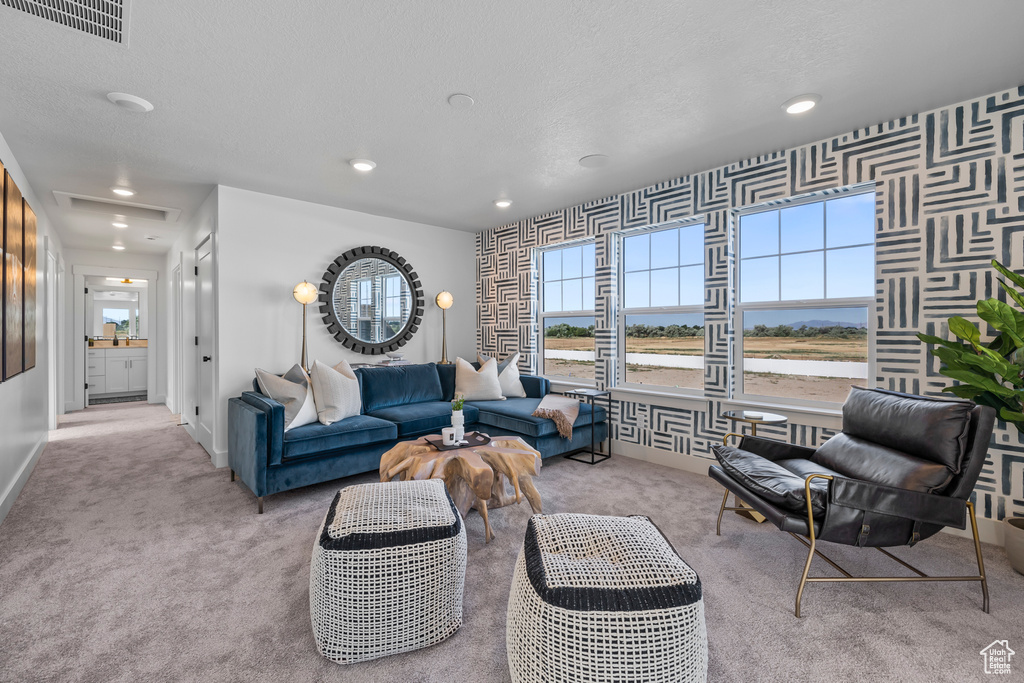 Living area with carpet, healthy amount of natural light, baseboards, recessed lighting, and wallpapered walls