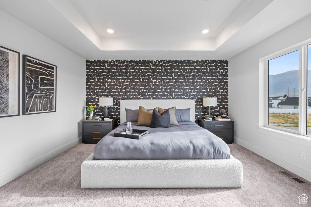 Bedroom with an accent wall, carpet floors, a raised ceiling, recessed lighting, and baseboards