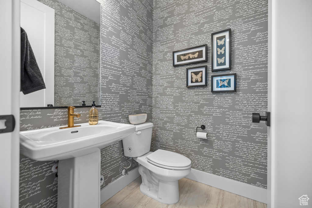 Half bath with toilet and wood finished floors