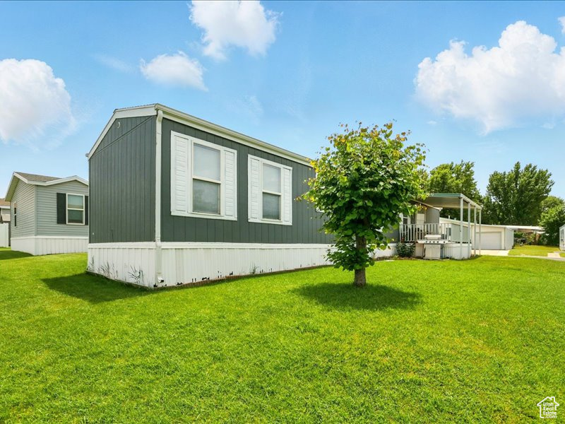 View of side of home featuring a yard