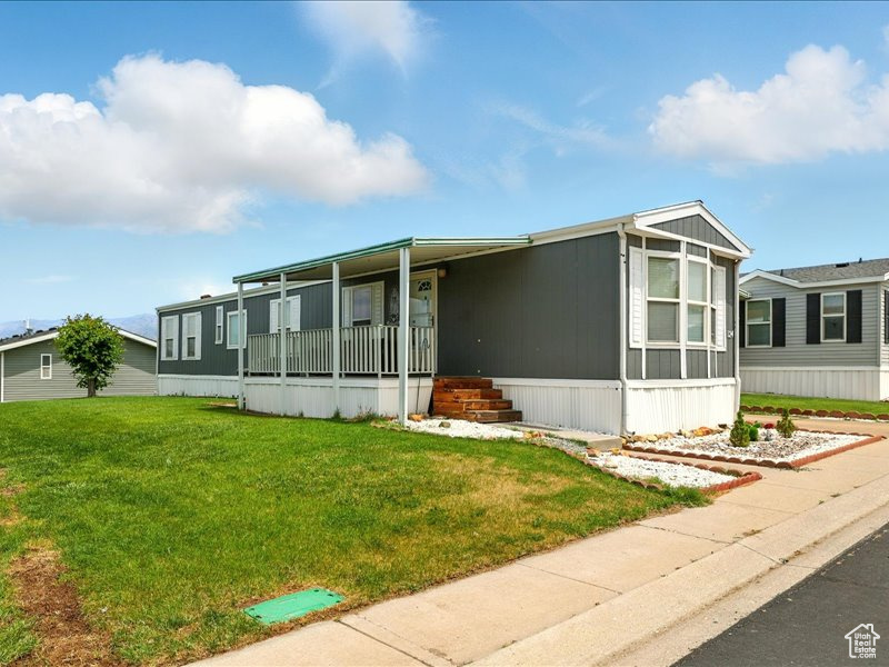 Manufactured / mobile home featuring a front lawn and a porch