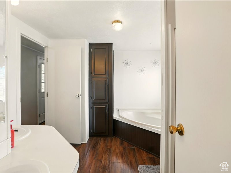 Bathroom featuring a garden tub and wood finished floors