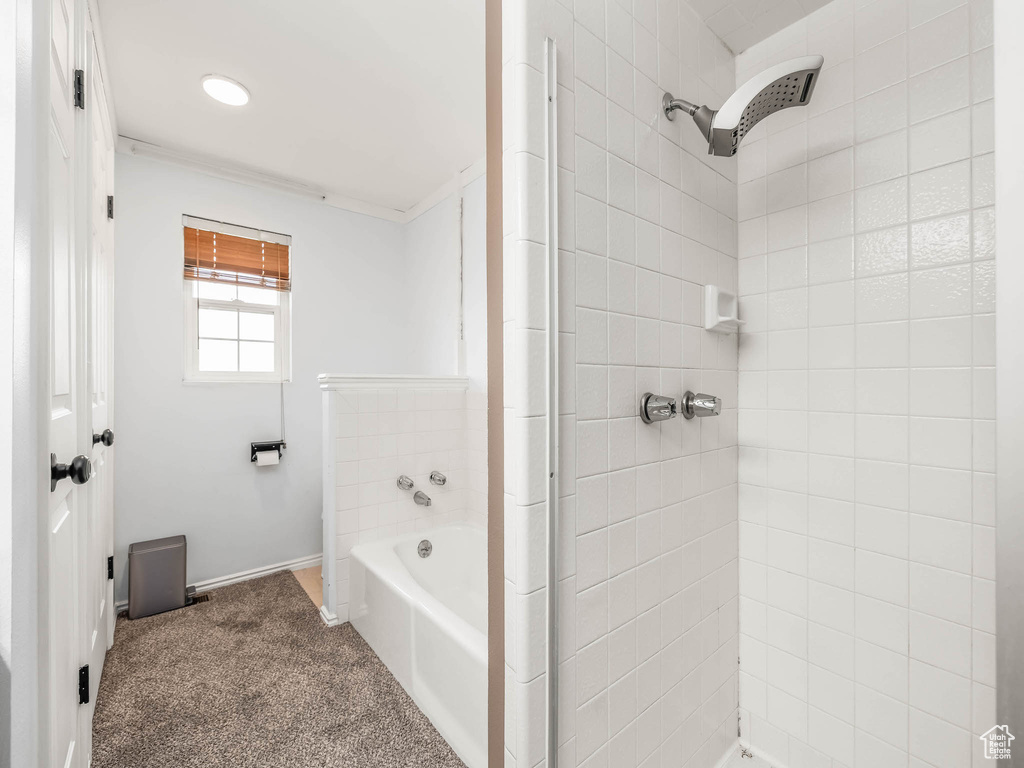 Full bath featuring a tile shower, a garden tub, and baseboards