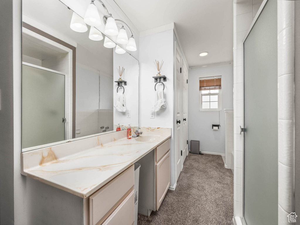 Bathroom with a stall shower, double vanity, and baseboards