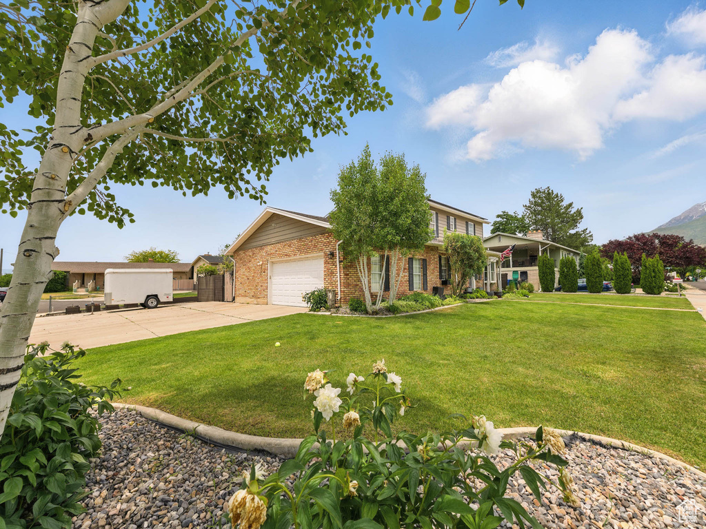 View of front of property featuring brick siding, concrete driveway, and a garage