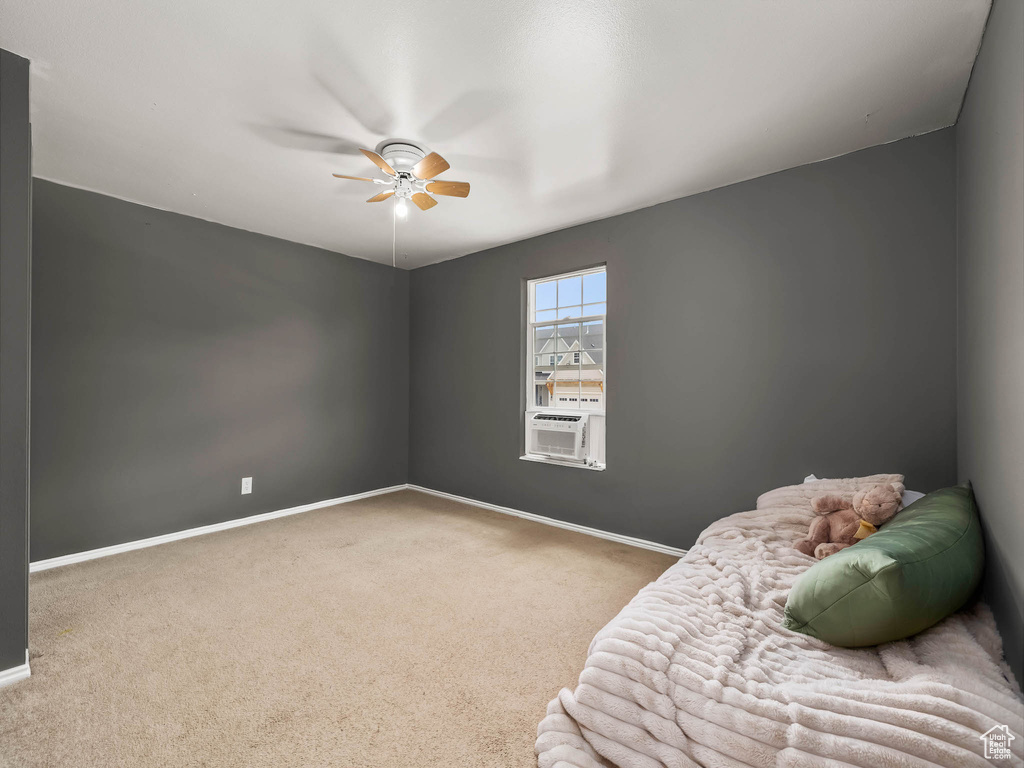 Bedroom with carpet, cooling unit, baseboards, and a ceiling fan