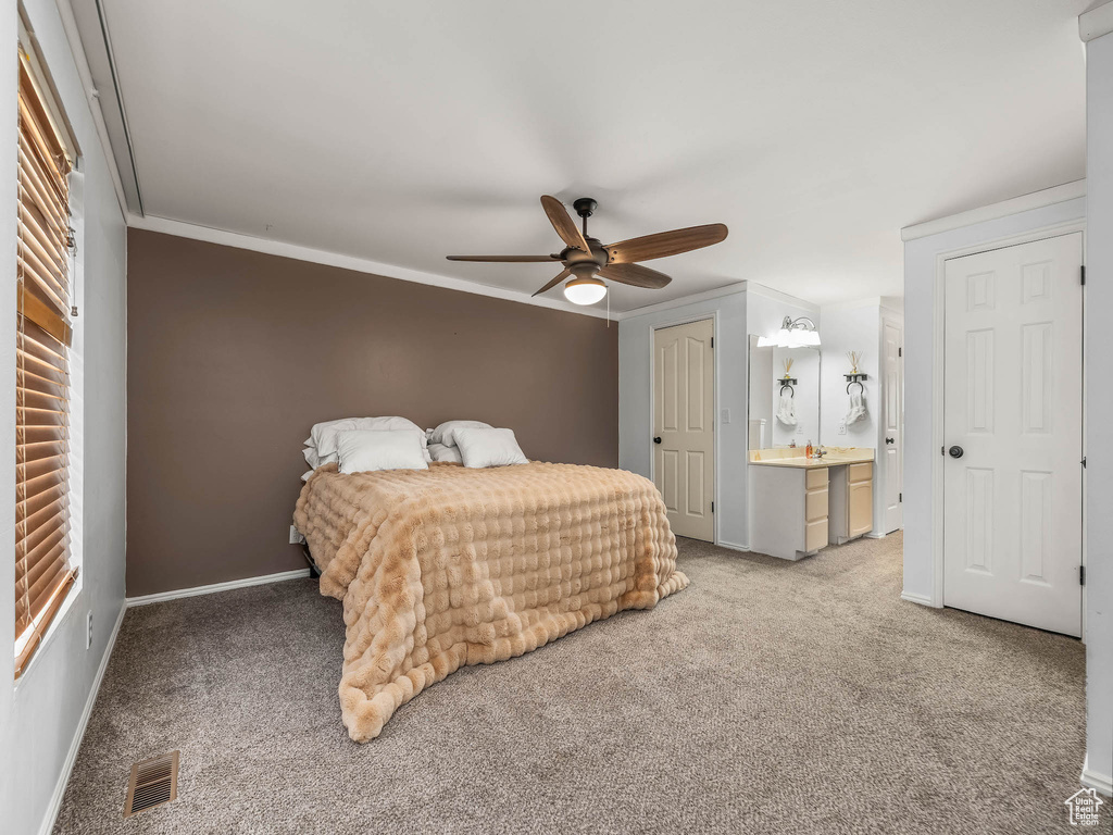 Carpeted bedroom featuring baseboards, ornamental molding, ceiling fan, and ensuite bathroom