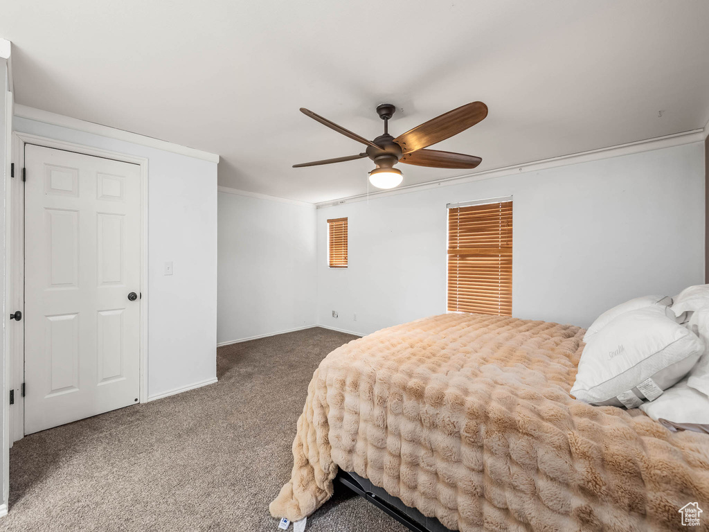 Bedroom featuring carpet, baseboards, ornamental molding, and ceiling fan