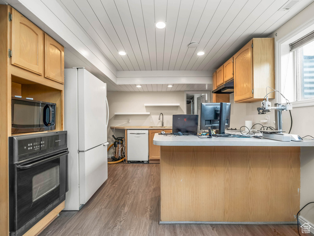 Kitchen featuring black appliances, a peninsula, a sink, wood finished floors, and wood ceiling