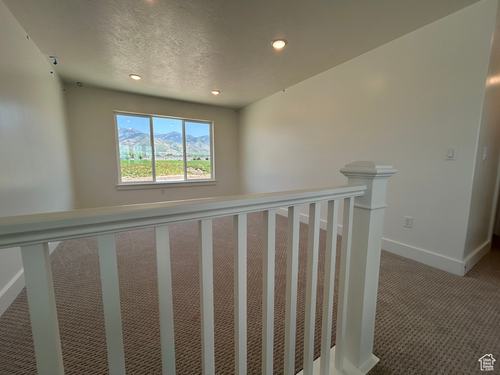 Hall featuring carpet floors, recessed lighting, baseboards, an upstairs landing, and a textured ceiling