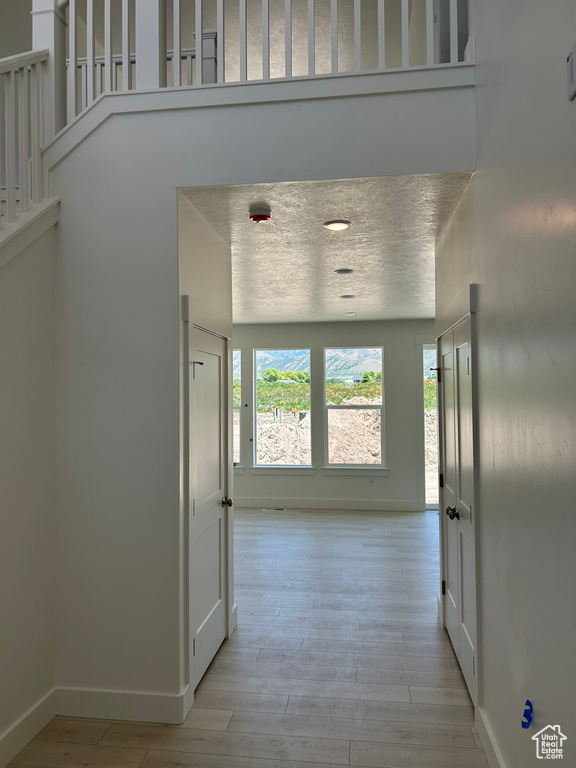 Corridor featuring baseboards and light wood finished floors