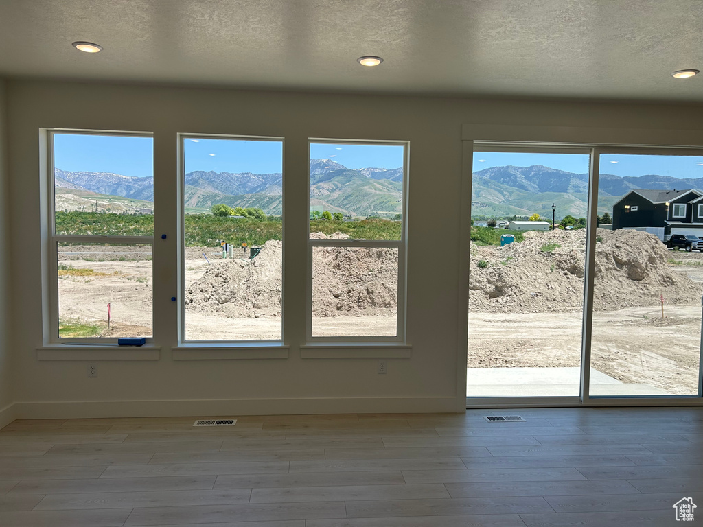 Entryway with a mountain view, baseboards, wood finished floors, recessed lighting, and a textured ceiling