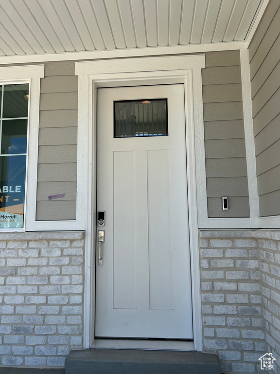 Property entrance featuring brick siding