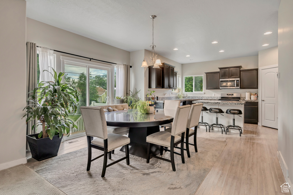 Dining room with recessed lighting and light wood-type flooring