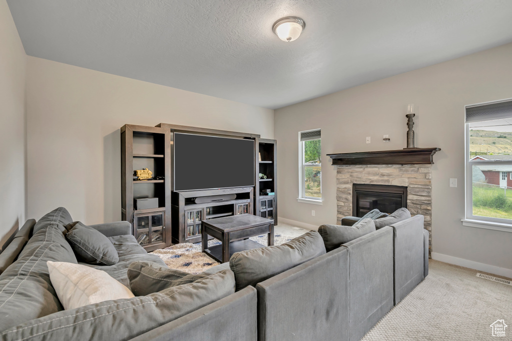 Living area with a fireplace and carpet