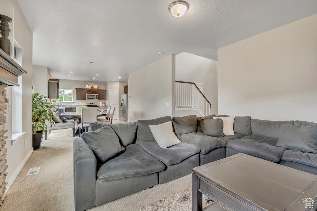 Living room featuring stairs, light carpet, and recessed lighting