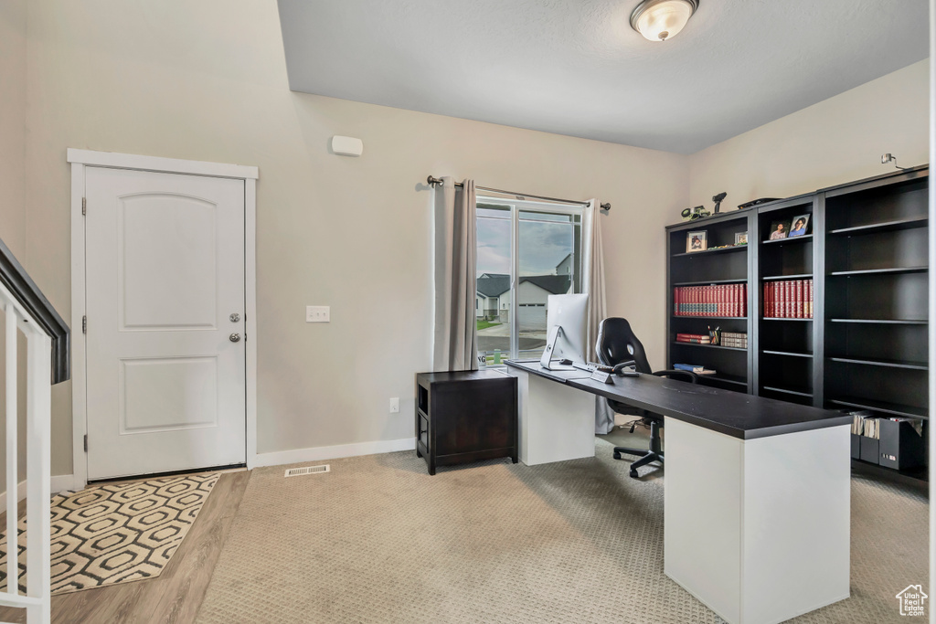 Home office featuring baseboards and light carpet