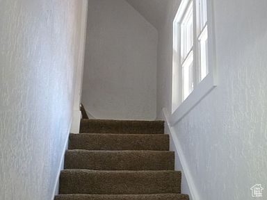Stairs featuring lofted ceiling