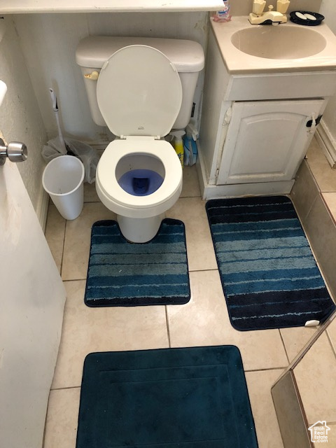 Bathroom featuring toilet, tile patterned flooring, and vanity