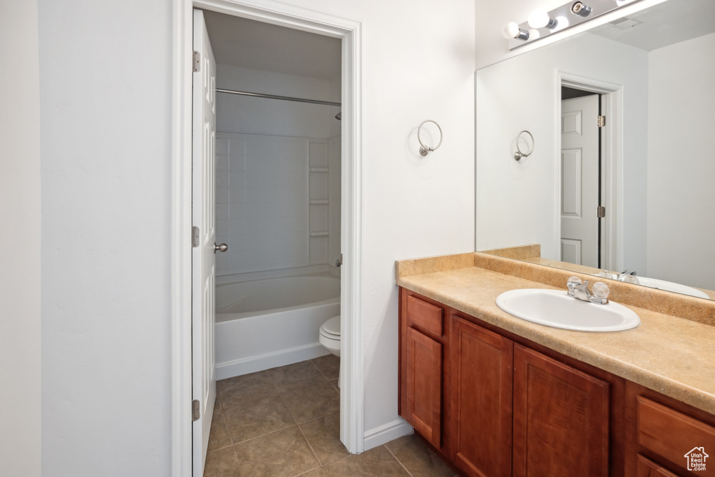 Full bath with vanity, tile patterned floors, toilet, shower / tub combination, and baseboards