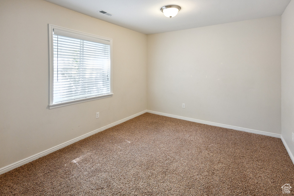 Carpeted empty room with baseboards
