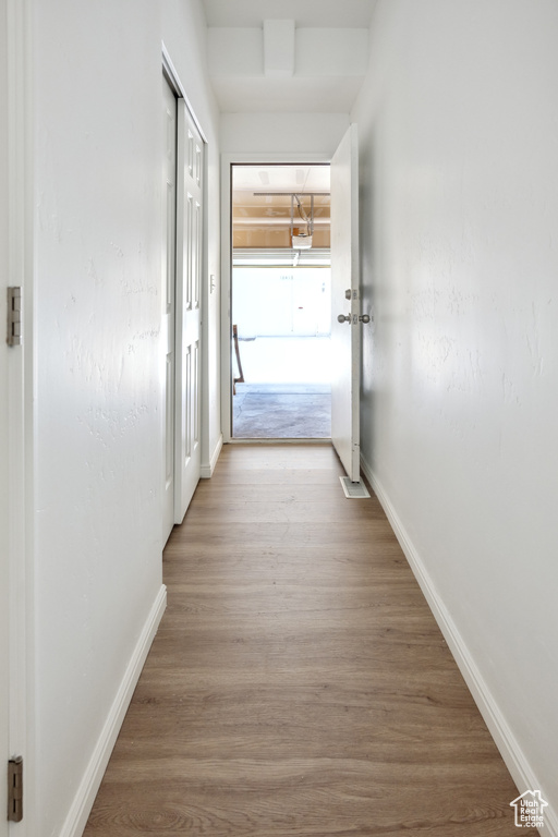 Hall featuring wood finished floors and baseboards