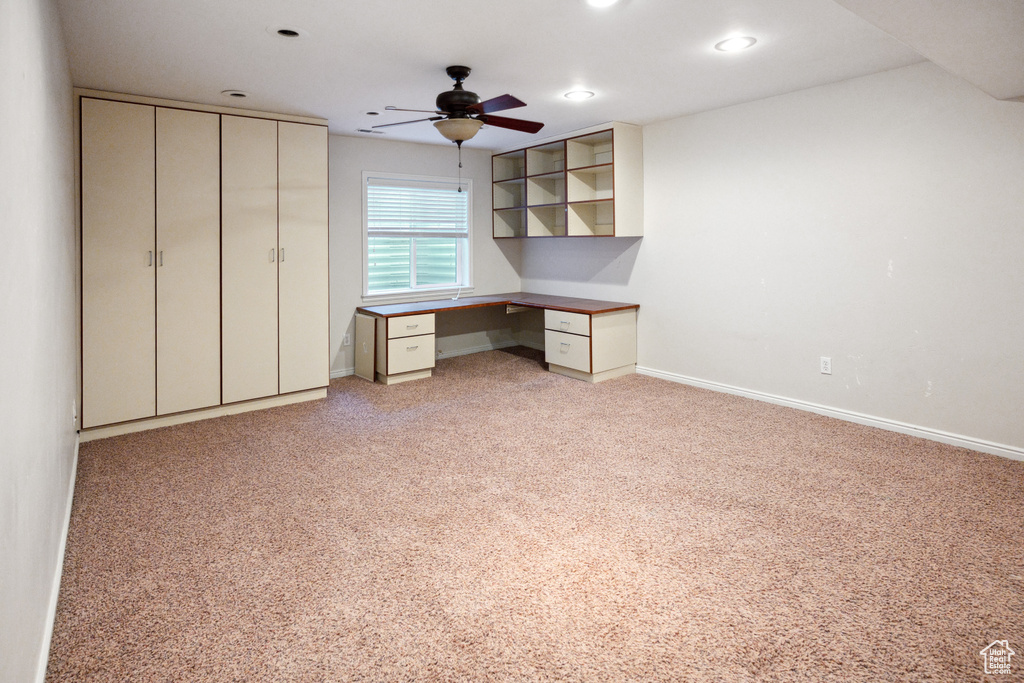 Unfurnished office featuring ceiling fan, built in study area, light carpet, baseboards, and recessed lighting
