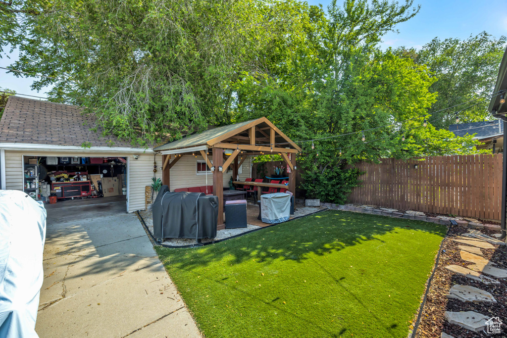 View of yard with a garage, an outdoor structure, and a gazebo