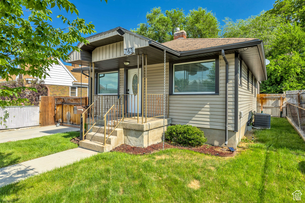 View of front of home featuring central AC unit and a chimney