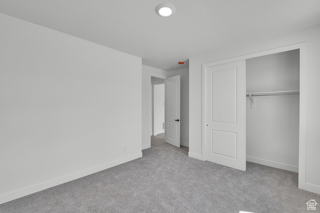 Unfurnished bedroom with carpet floors, baseboards, and a closet