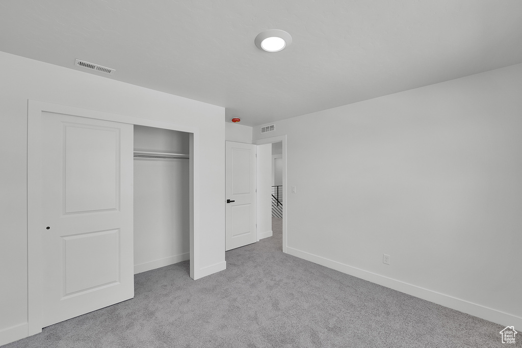 Unfurnished bedroom featuring carpet floors, a closet, and baseboards