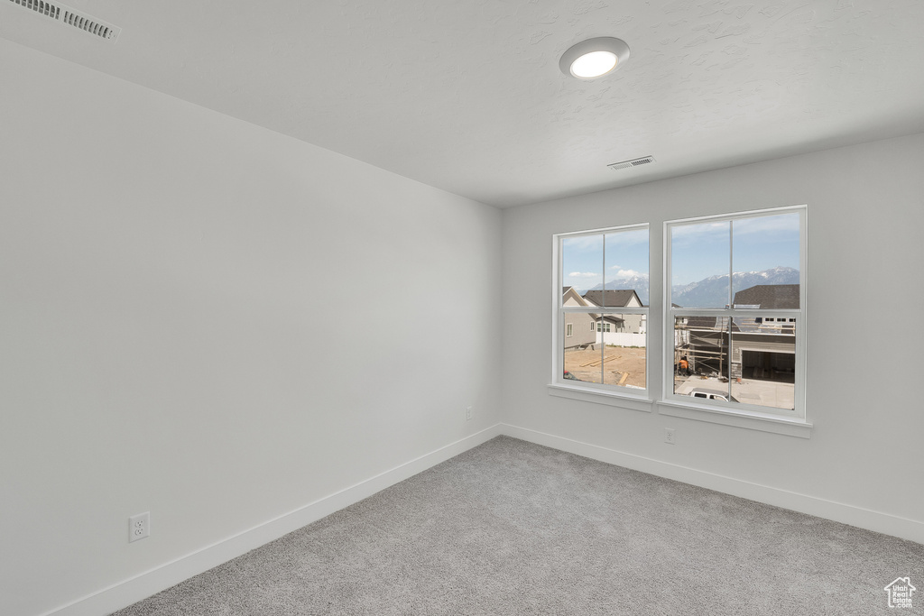 Carpeted empty room with baseboards