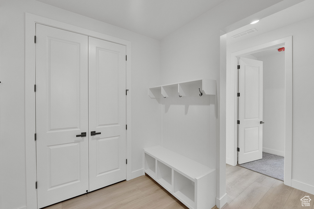 Mudroom with light wood-style floors and baseboards