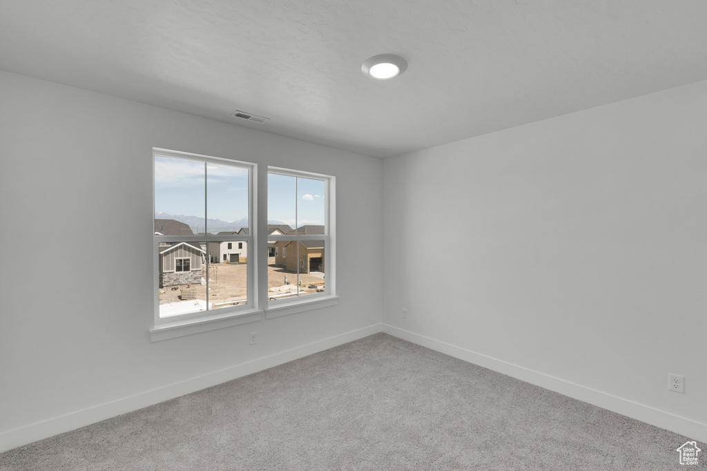 Carpeted spare room with baseboards