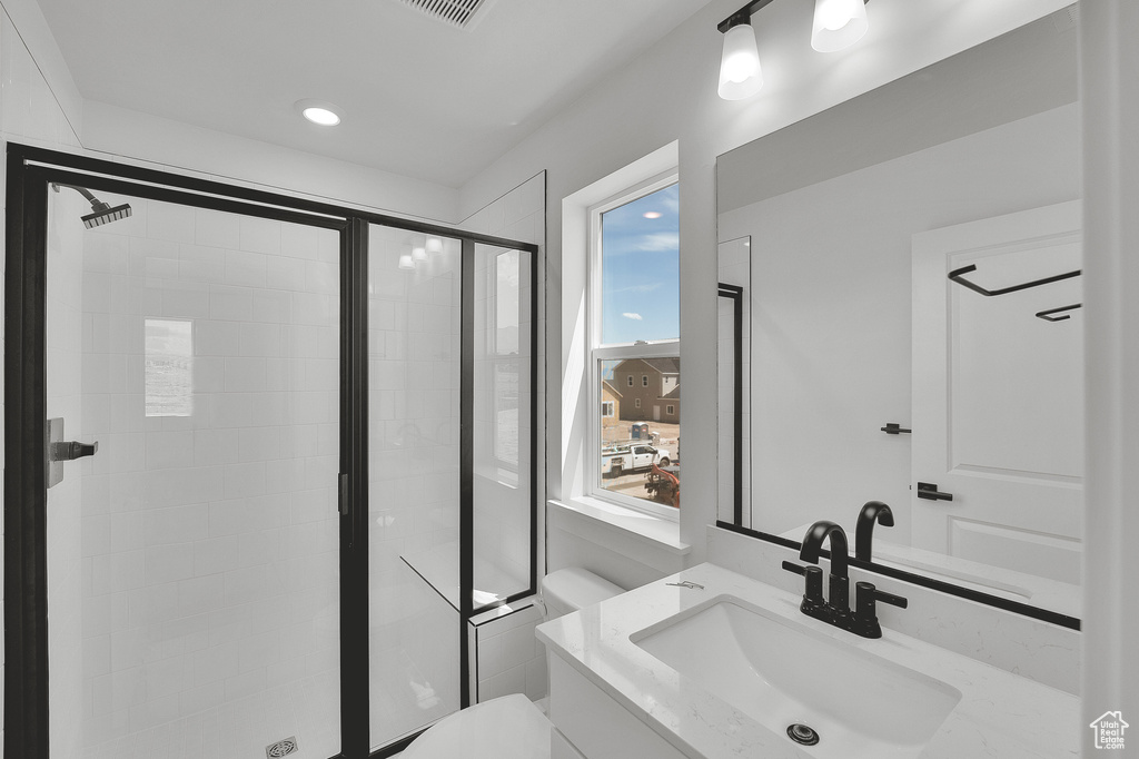 Bathroom with a shower stall, vanity, and toilet