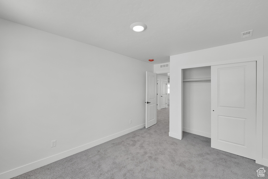 Unfurnished bedroom with carpet floors, baseboards, and a closet