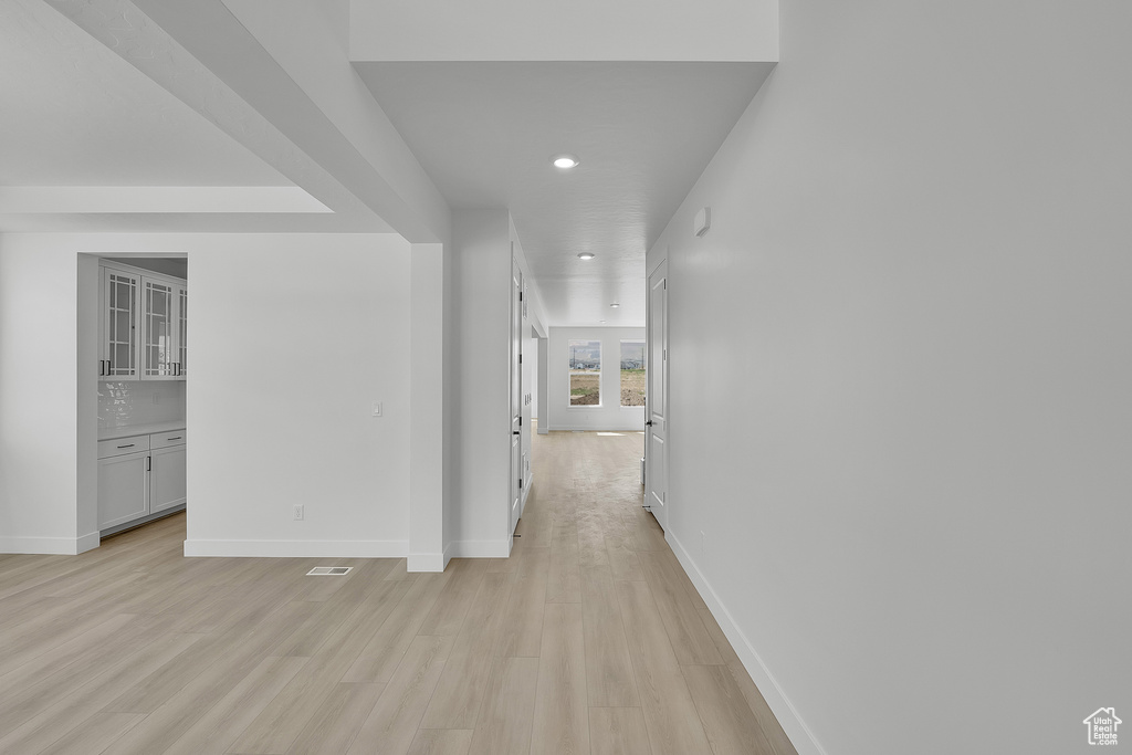 Corridor featuring light wood-style floors, baseboards, and recessed lighting