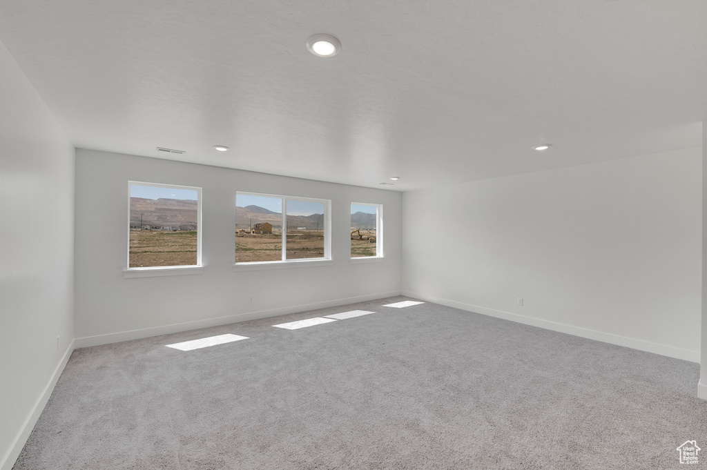 Carpeted empty room featuring baseboards and recessed lighting