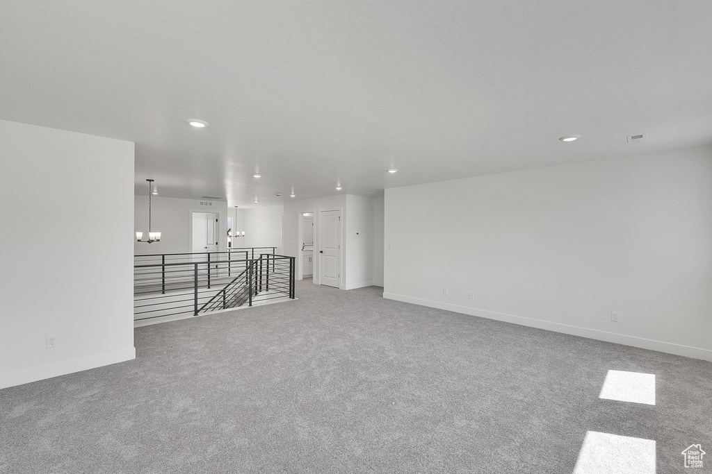 Carpeted spare room with recessed lighting, a chandelier, and baseboards