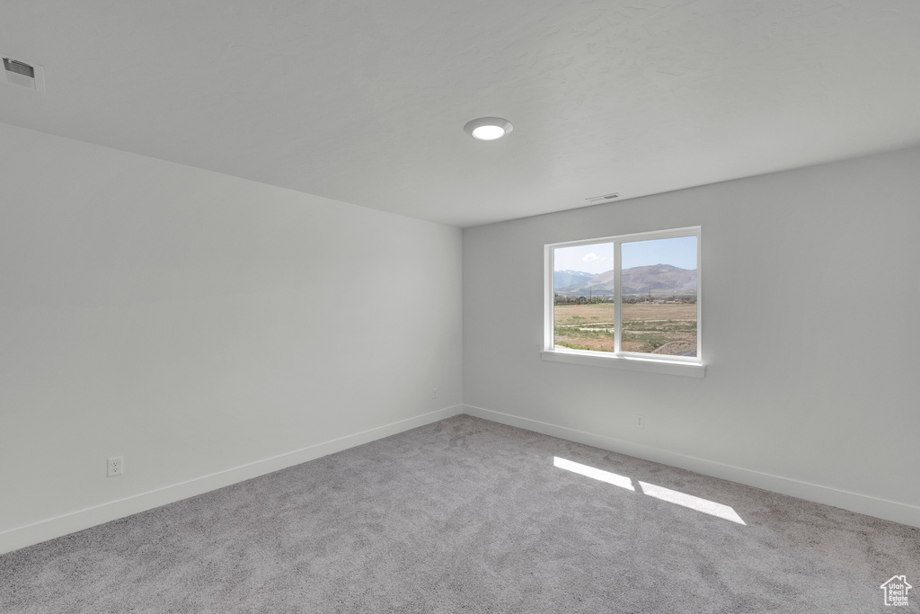 Carpeted spare room with baseboards