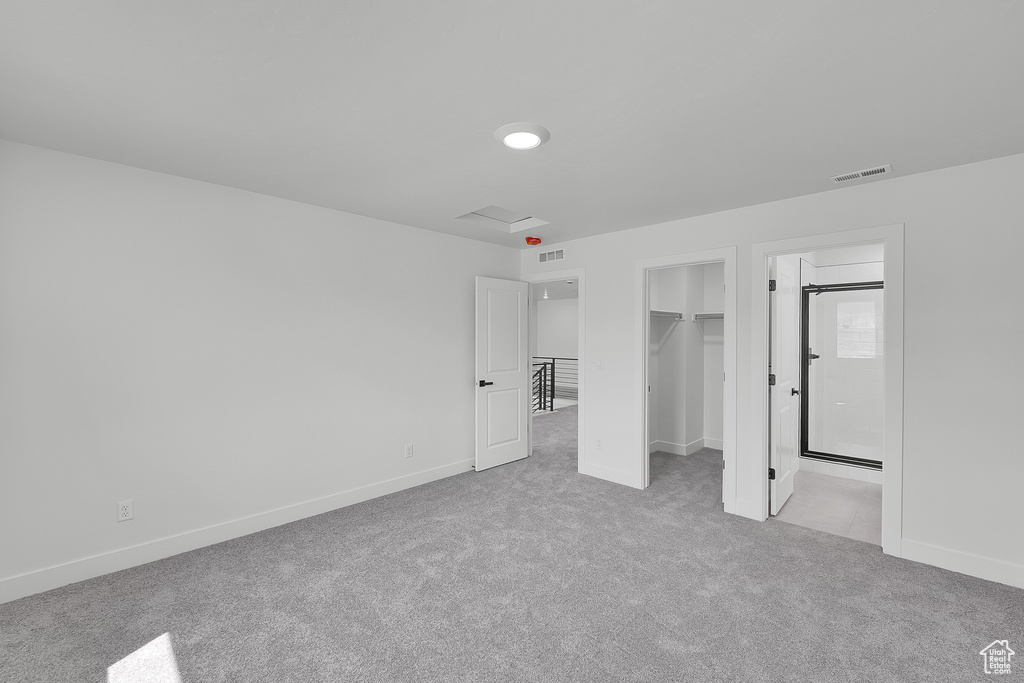 Unfurnished bedroom with carpet floors, a walk in closet, baseboards, and a closet