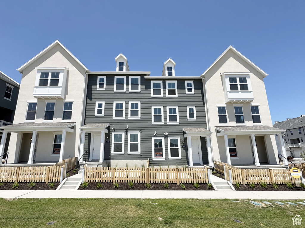 View of property featuring covered porch and a fenced front yard