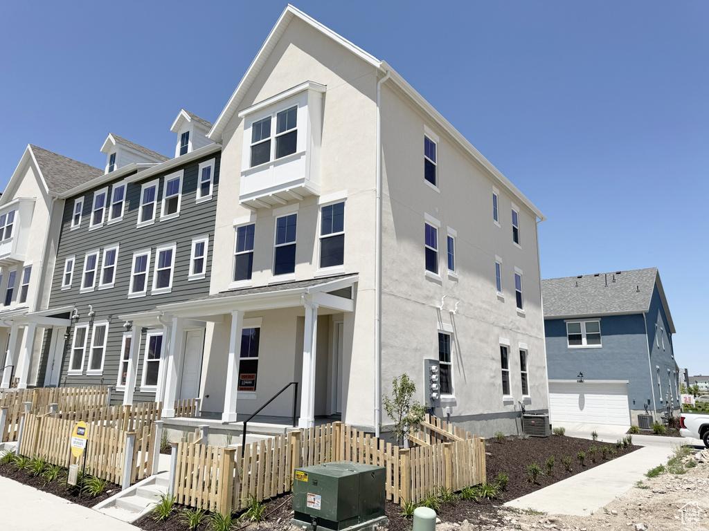 Multi unit property with central air condition unit, stucco siding, and a porch