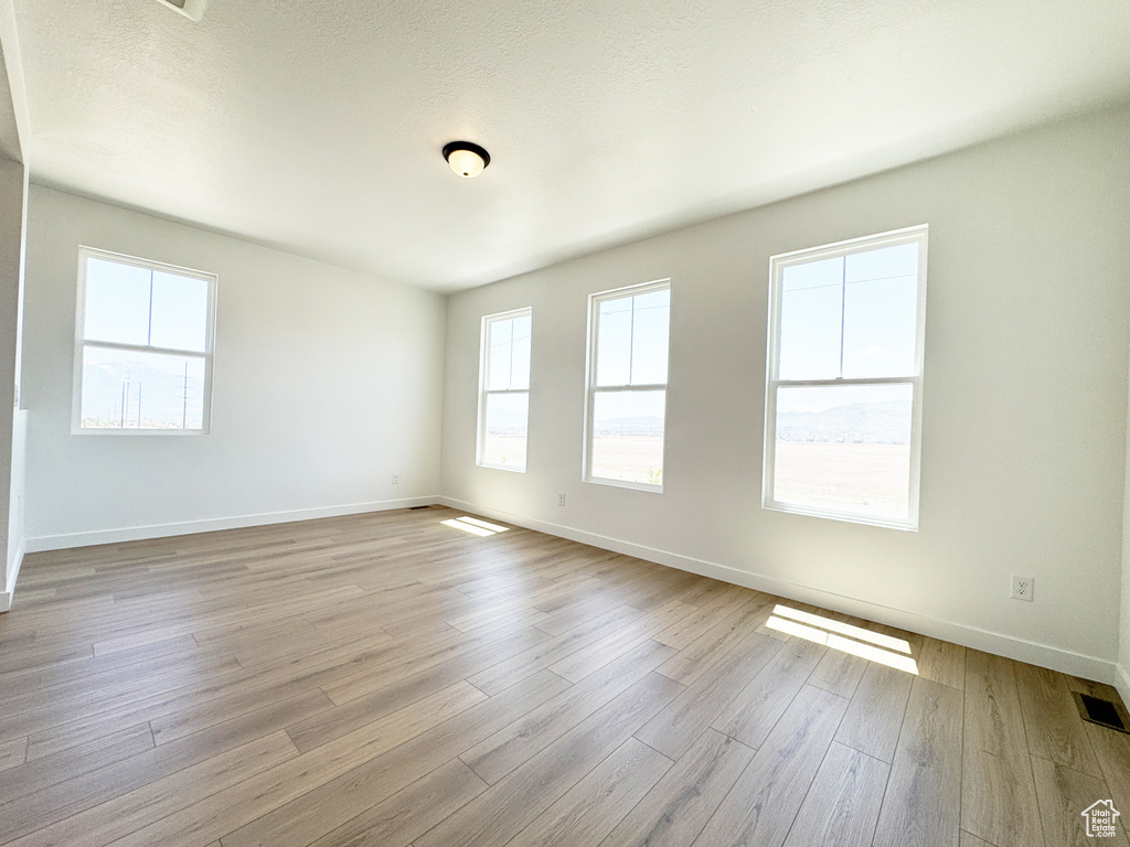 Spare room featuring baseboards and wood finished floors