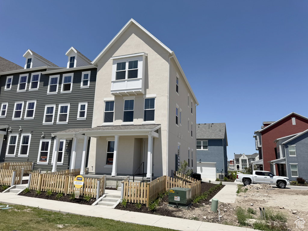 Townhome / multi-family property featuring a porch and stucco siding