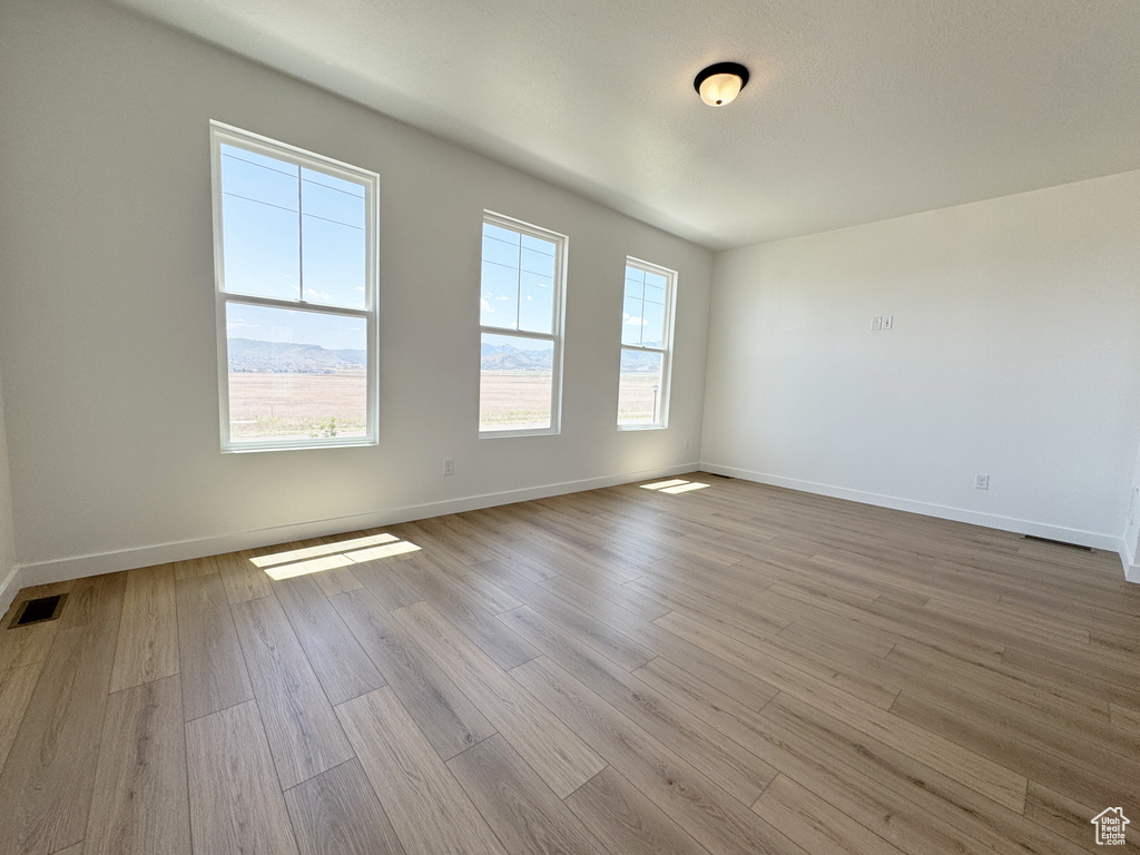 Spare room featuring wood finished floors and baseboards