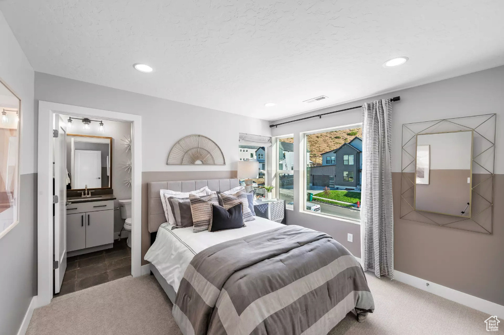 Bedroom with a sink, carpet, recessed lighting, and ensuite bath